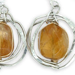 Sterling silver hammered knot earrings holding citrine nugget gemstones