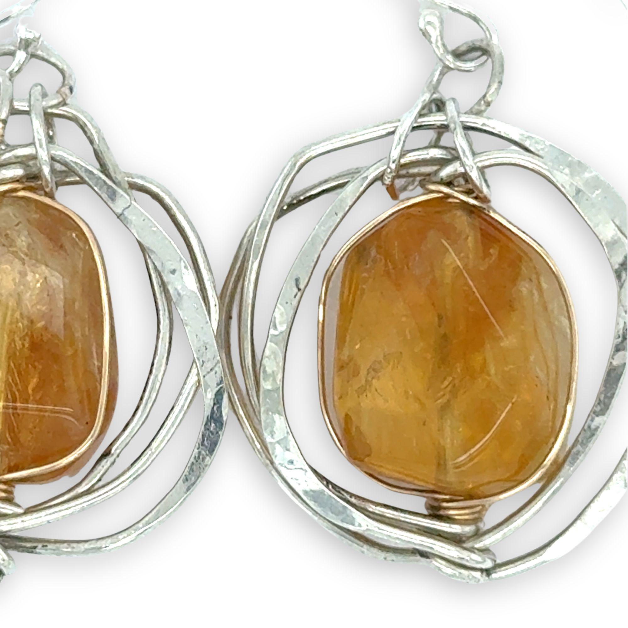 Sterling silver hammered knot earrings holding citrine nugget gemstones
