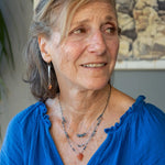 Handmade hammered sterling silver bar earrings with a rust orange colored fresh water pearl dangle