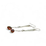 Handmade hammered sterling silver bar earrings with a rust orange colored fresh water pearl dangle
