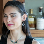 A pair of sterling silver earrings with blue crystal teardrops, apatite, crystal, and sodalite gemstones