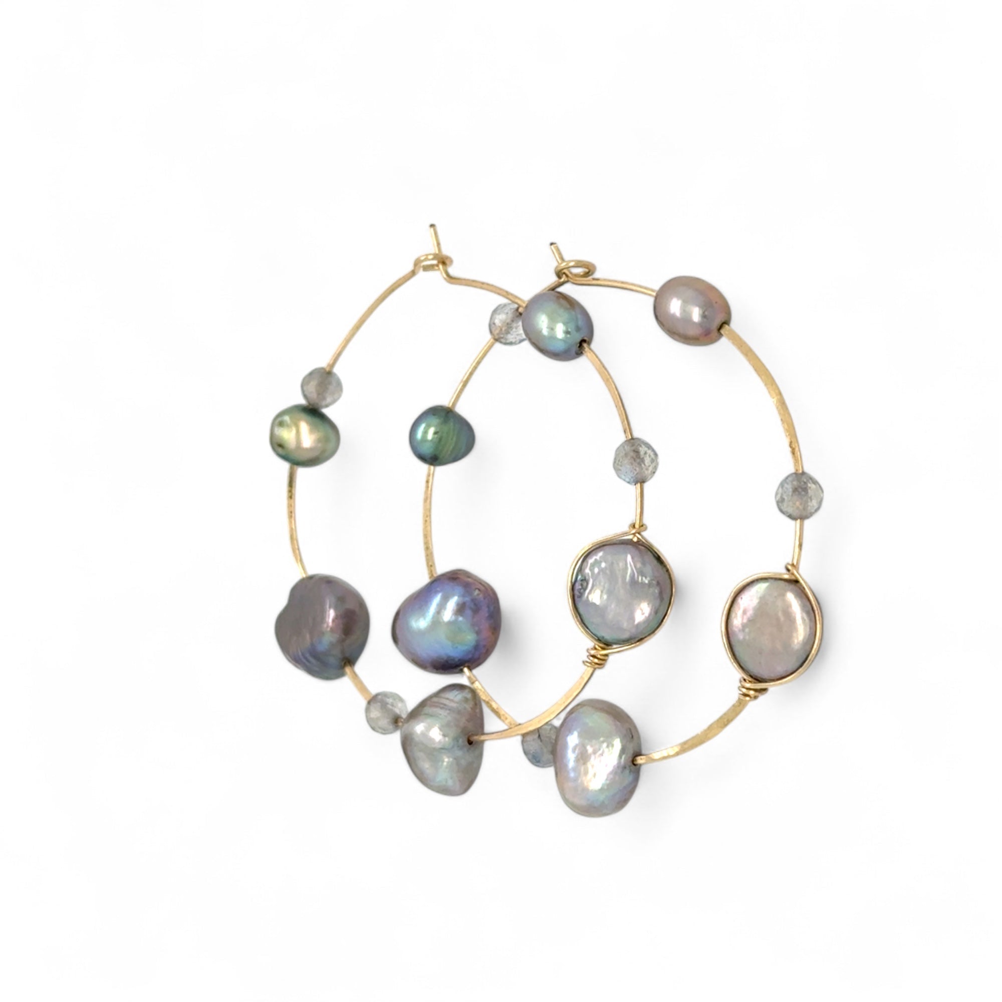 A pair of gold-filled hammered hoop earrings with pastel freshwater pearls set into them.