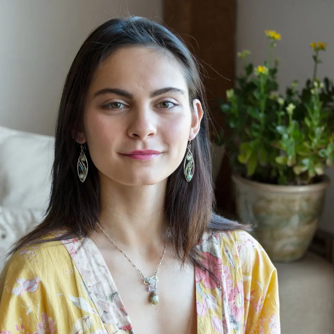 A pair of sterling silver sprout marquise earrings featuring glowing green fire agate, faceted pink garnet, and green kyanite gemstones, with braided oxidized sterling silver veins and silver French hooks.
