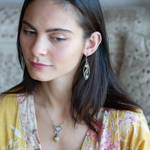 A pair of sterling silver sprout marquise earrings featuring glowing green fire agate, faceted pink garnet, and green kyanite gemstones, with braided oxidized sterling silver veins and silver French hooks.
