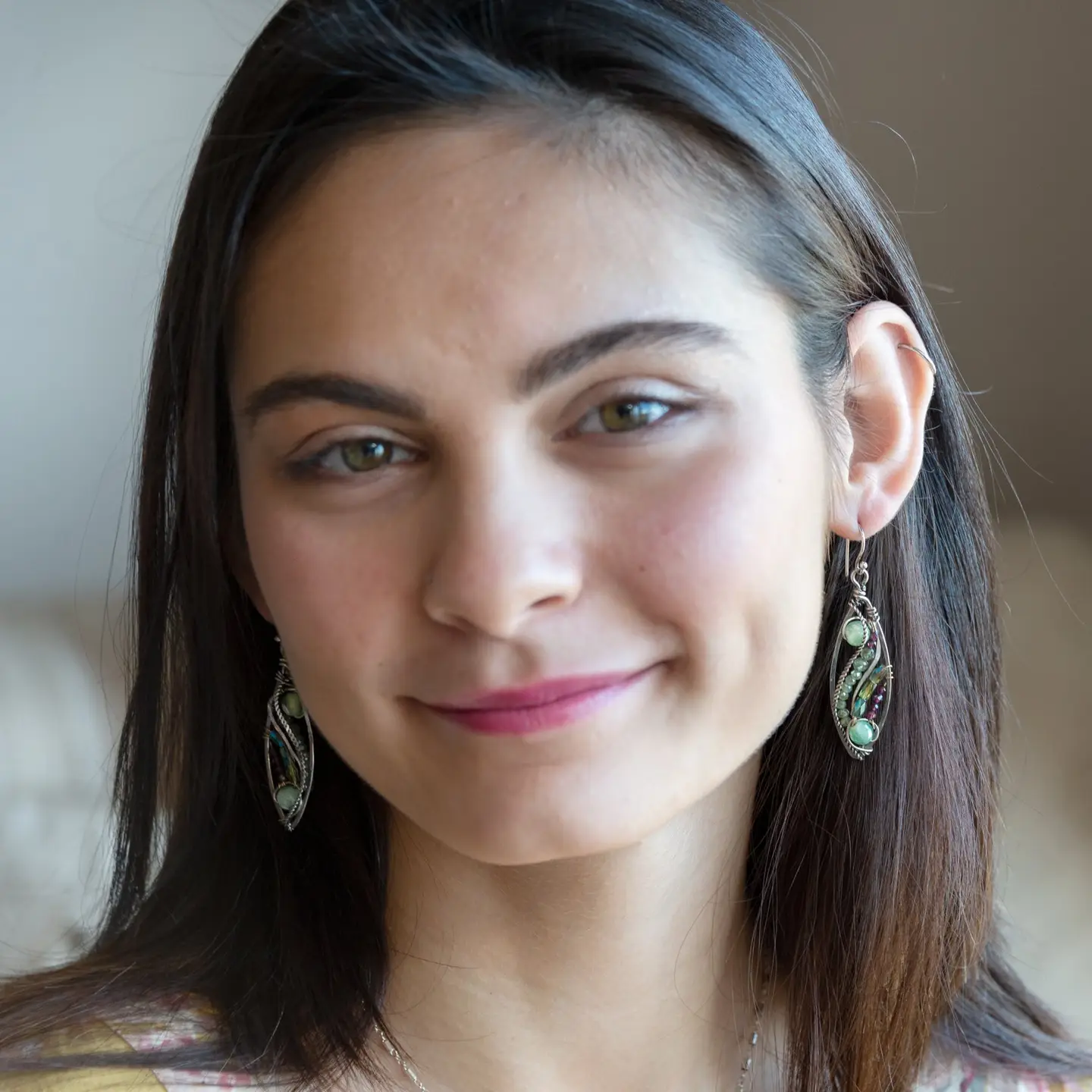 A pair of sterling silver sprout marquise earrings featuring glowing green fire agate, faceted pink garnet, and green kyanite gemstones, with braided oxidized sterling silver veins and silver French hooks.