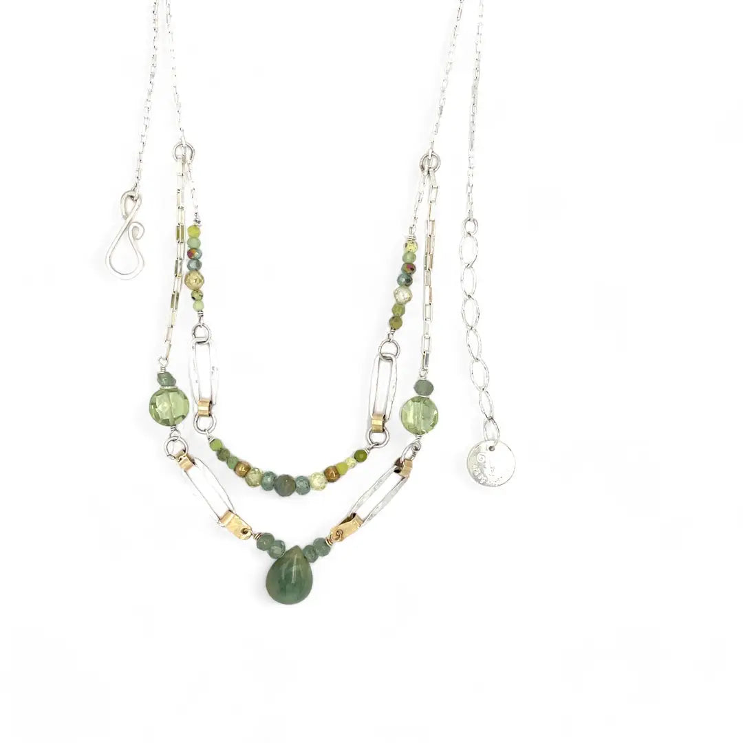A double chain necklace with handmade hammered sterling silver rectangles and brass rings and straps, with green amethyst, green kyanite, crystal, cubic zirconia, and african metal beads