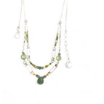 A double chain necklace with handmade hammered sterling silver rectangles and brass rings and straps, with green amethyst, green kyanite, crystal, cubic zirconia, and african metal beads