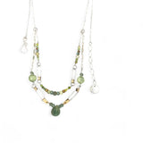 A double chain necklace with handmade hammered sterling silver rectangles and brass rings and straps, with green amethyst, green kyanite, crystal, cubic zirconia, and african metal beads