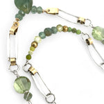 A double chain necklace with handmade hammered sterling silver rectangles and brass rings and straps, with green amethyst, green kyanite, crystal, cubic zirconia, and african metal beads