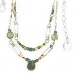A double chain necklace with handmade hammered sterling silver rectangles and brass rings and straps, with green amethyst, green kyanite, crystal, cubic zirconia, and african metal beads