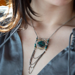 Turquoise tile held within layers of sterling silver wire suspended between lines of brass and oxidized sterling silver twist bars. Side pieces include blue quartz, chrysocolla, and pyrite gemstones, Oxidized sterling silver satellite dot chain chandelier bottom