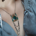 Turquoise tile held within layers of sterling silver wire suspended between lines of brass and oxidized sterling silver twist bars. Side pieces include blue quartz, chrysocolla, and pyrite gemstones, Oxidized sterling silver satellite dot chain chandelier bottom