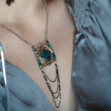 Turquoise tile held within layers of sterling silver wire suspended between lines of brass and oxidized sterling silver twist bars. Side pieces include blue quartz, chrysocolla, and pyrite gemstones, Oxidized sterling silver satellite dot chain chandelier bottom