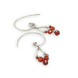 Tiny hammered sterling silver teardrops with red cubic zirconia hang from our handmade sterling silver hoop earrings