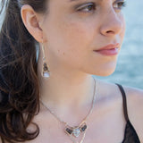 A brass and sterling silver pendant necklace featuring a blue lace agate point and faceted flashy labradorite gemstones with a doubled sterling silver sparkly chain