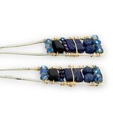Lapis and onyx gemstones stacked with blue crystal on gold filled wire within a skinny, tall sterling silver triangle shaped earrings