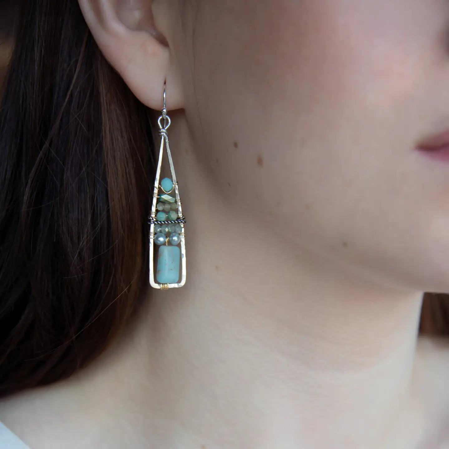 Terra verde smooth oval gemstones layered with light blue fresh water pearl, crystal, and amazonite gemstones on gold filled wire within skinny triangle shaped earrings