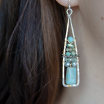 Terra verde smooth oval gemstones layered with light blue fresh water pearl, crystal, and amazonite gemstones on gold filled wire within skinny triangle shaped earrings