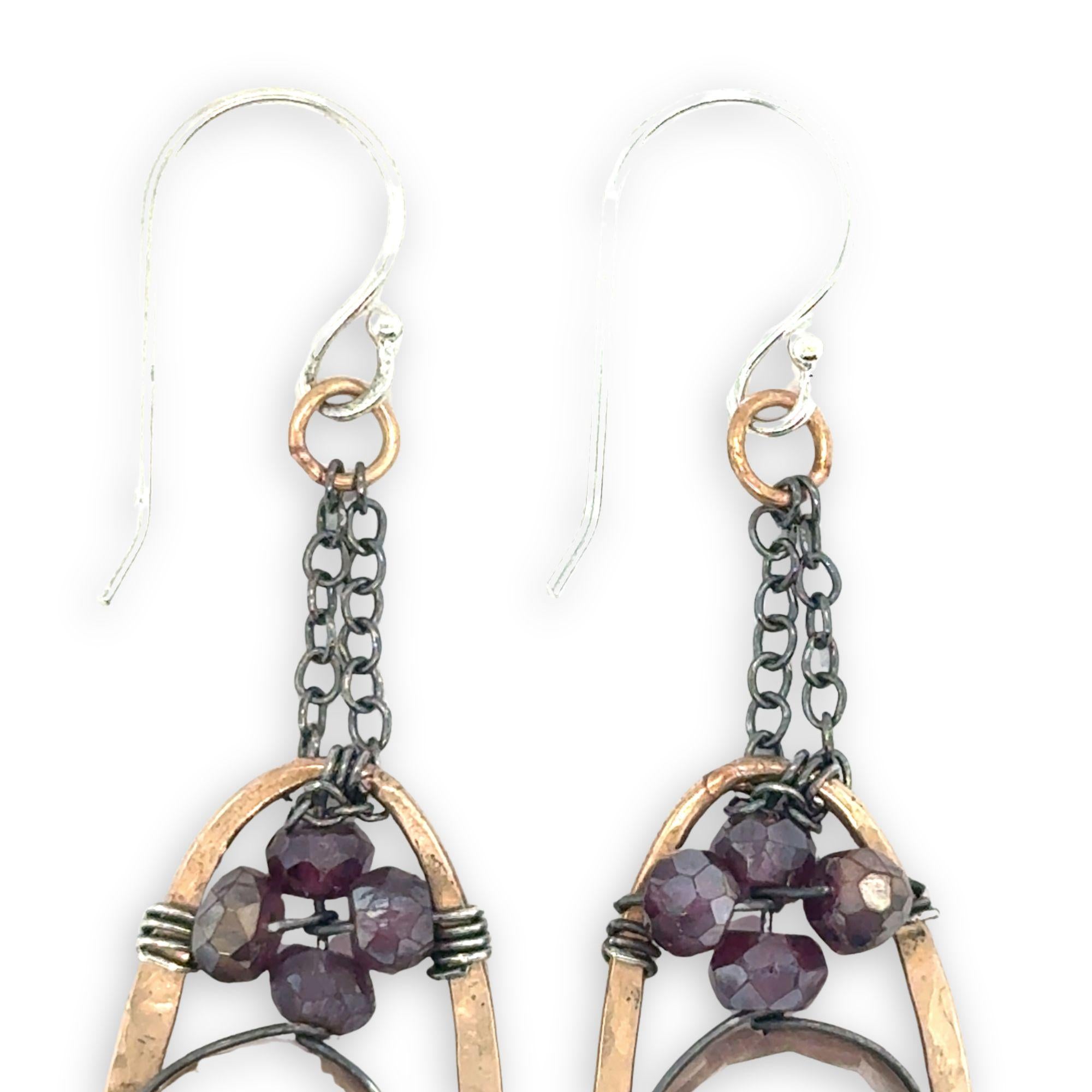 hammered bronze oval earrings with moonstone and garnet faceted gemstones in oxidized sterling silver wire hanging from oxidized sterling delicate chain