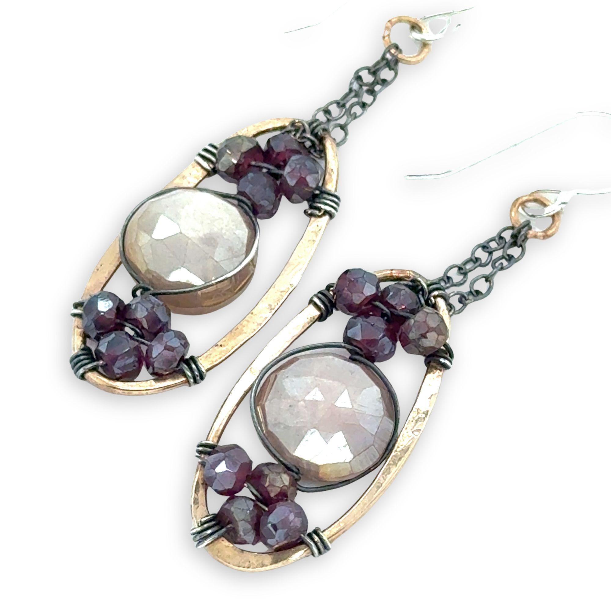 hammered bronze oval earrings with moonstone and garnet faceted gemstones in oxidized sterling silver wire hanging from oxidized sterling delicate chain