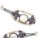 hammered bronze oval earrings with moonstone and garnet faceted gemstones in oxidized sterling silver wire hanging from oxidized sterling delicate chain