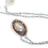 Bronze oval pendant filled with mauve moonstone, garnet, and pyrite gemstones with a darkened sterling silver oval chain necklace