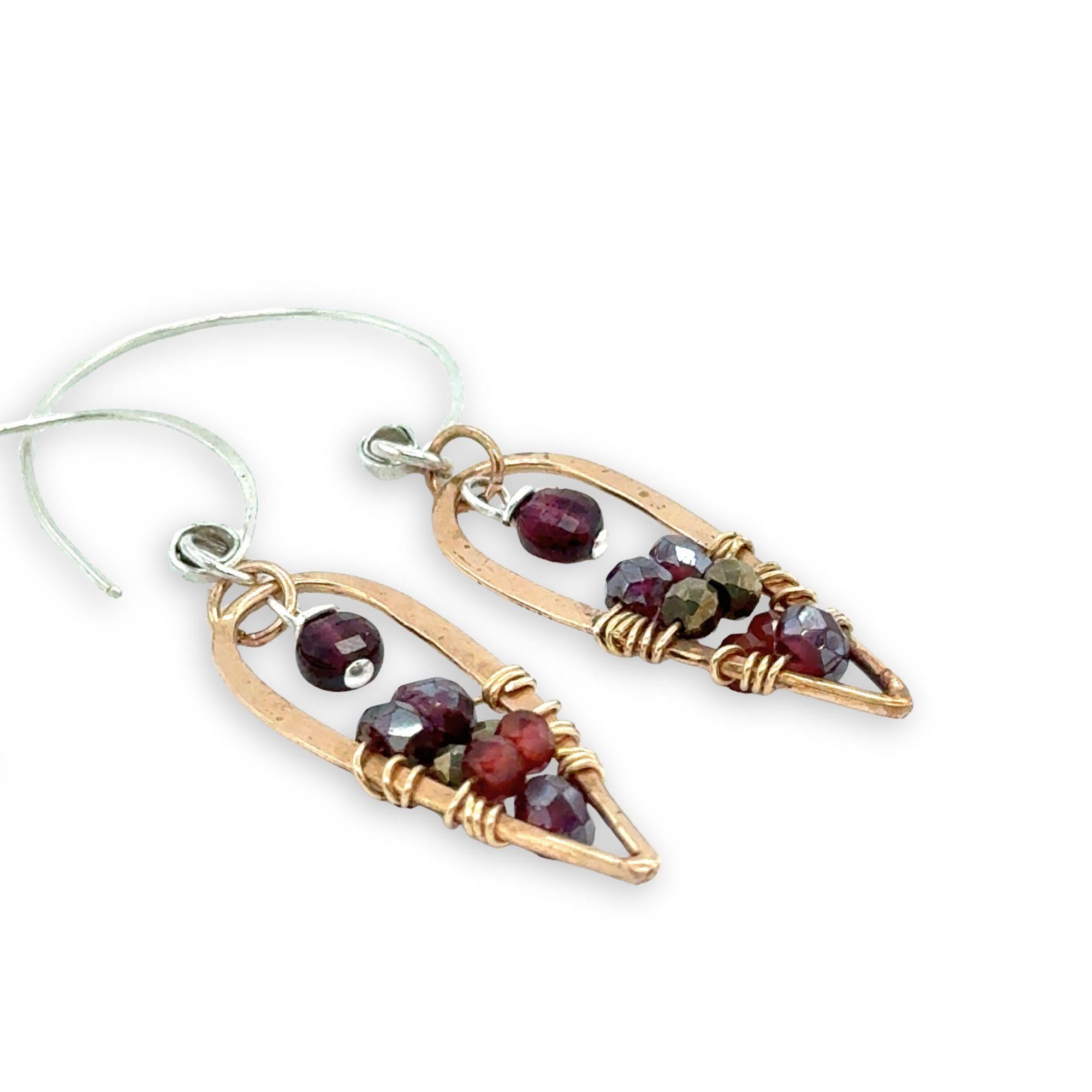 mini bronze teardrops filled with garnet and pyrite gemstones hanging from our handmade sterling silver hoop earrings