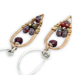 mini bronze teardrops filled with garnet and pyrite gemstones hanging from our handmade sterling silver hoop earrings