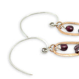 mini bronze teardrops filled with garnet and pyrite gemstones hanging from our handmade sterling silver hoop earrings