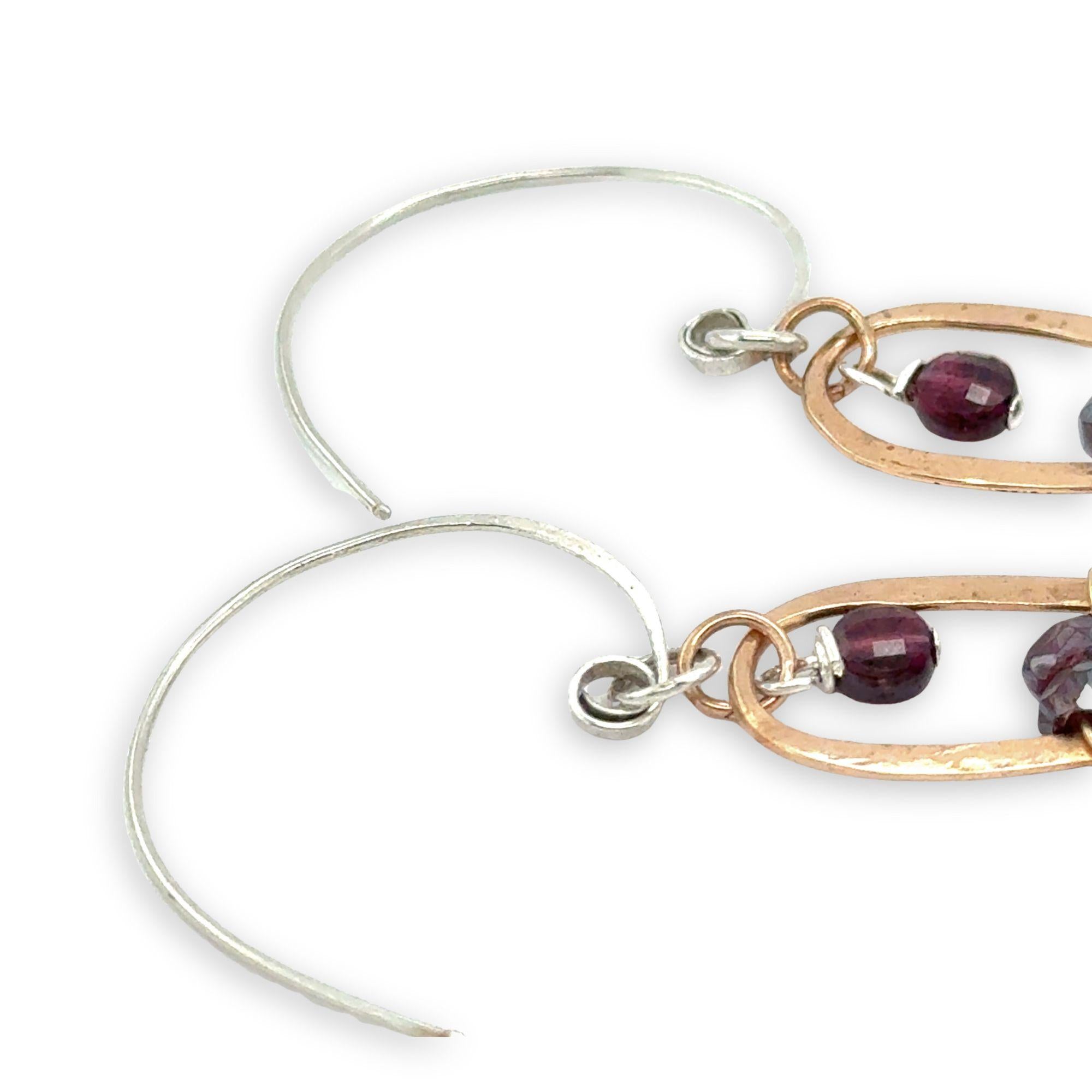 mini bronze teardrops filled with garnet and pyrite gemstones hanging from our handmade sterling silver hoop earrings