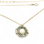 A brass hammered hexagon pendant necklace with a central pearl surrounded by a spiral of rutilated quartz and green kyanite gemstones, on a gold-filled rolo chain 