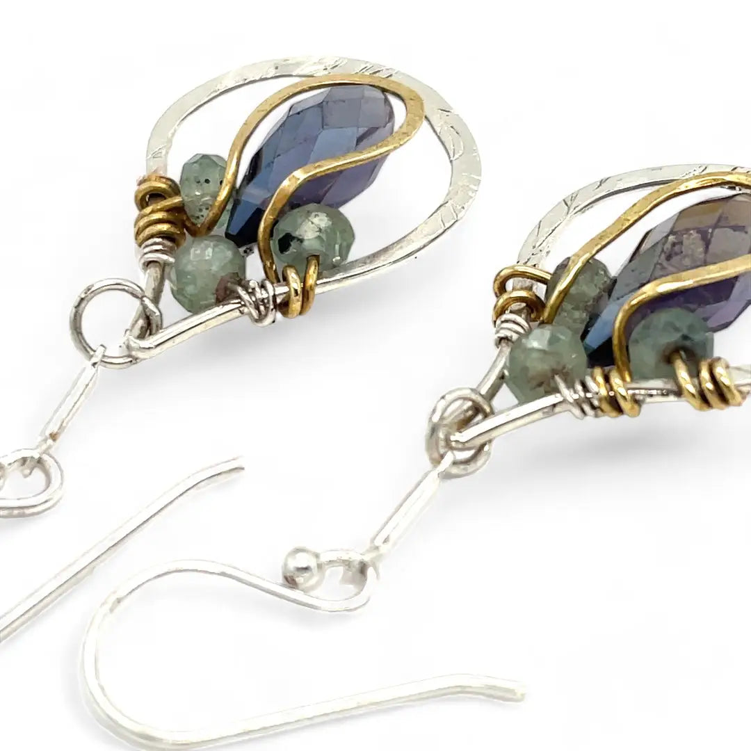 Sterling silver leaf stamped drop earrings with green kyanite gemstones and purple crystal drops wrapped in hammered brass wire, on sterling silver bar chain
