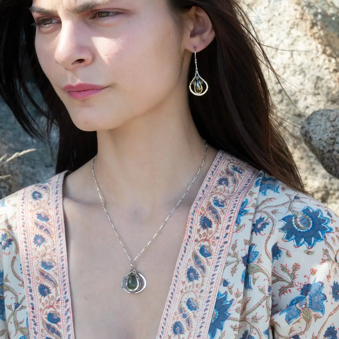 Sterling silver leaf stamped drop earrings with green kyanite gemstones and purple crystal drops wrapped in hammered brass wire, on sterling silver bar chain