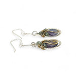 Sterling silver leaf stamped drop earrings with green kyanite gemstones and purple crystal drops wrapped in hammered brass wire, on sterling silver bar chain