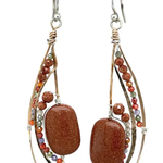 Bronze elongated semi circle earrings with goldstone gemstones and multi colored cubic zirconia