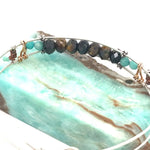 Skinny sterling silver hammered bracelet with faceted tiger's eye, amazonite, and pyrite gemstones, featuring darkened sterling silver twist and bronze hammered accents