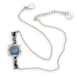 blue kyanite tile held between sterling silver fish tin shape necklace accented with aquamarine faceted gemstones