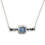 blue kyanite tile held between sterling silver fish tin shape necklace accented with aquamarine faceted gemstones