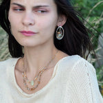 A pair of sterling silver and bronze hammered earrings with smooth prehnite coin and watermelon tourmaline gemstones, with built in earring hooks to wear like a post earring.