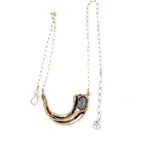 A satiny mauve moonstone necklace with bronze waves and tourmaline micro faceted gemstones, featuring a gold filled chain and a sterling silver signature clasp.