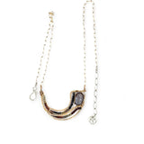 A satiny mauve moonstone necklace with bronze waves and tourmaline micro faceted gemstones, featuring a gold filled chain and a sterling silver signature clasp.