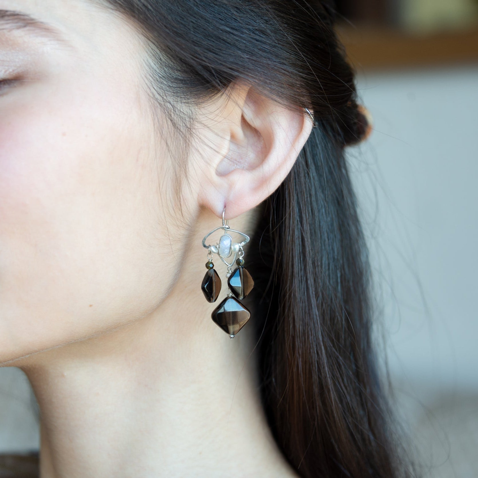 Smokey quartz tile and olive cat's eye gemstones hang from sterling silver triangle earrings filled with moonstone and fresh water pearl, featuring sterling silver earring hooks built in to wear like a post earring