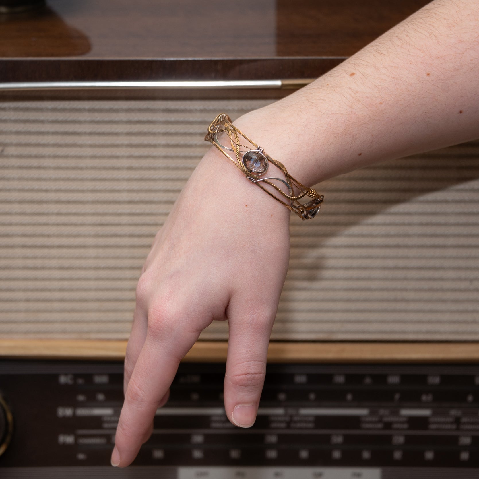 champagne colored faceted crystals held in braided layers of sterling silver, bronze and twisted brass hammered wires all inside a bronze cuff handmade bracelet