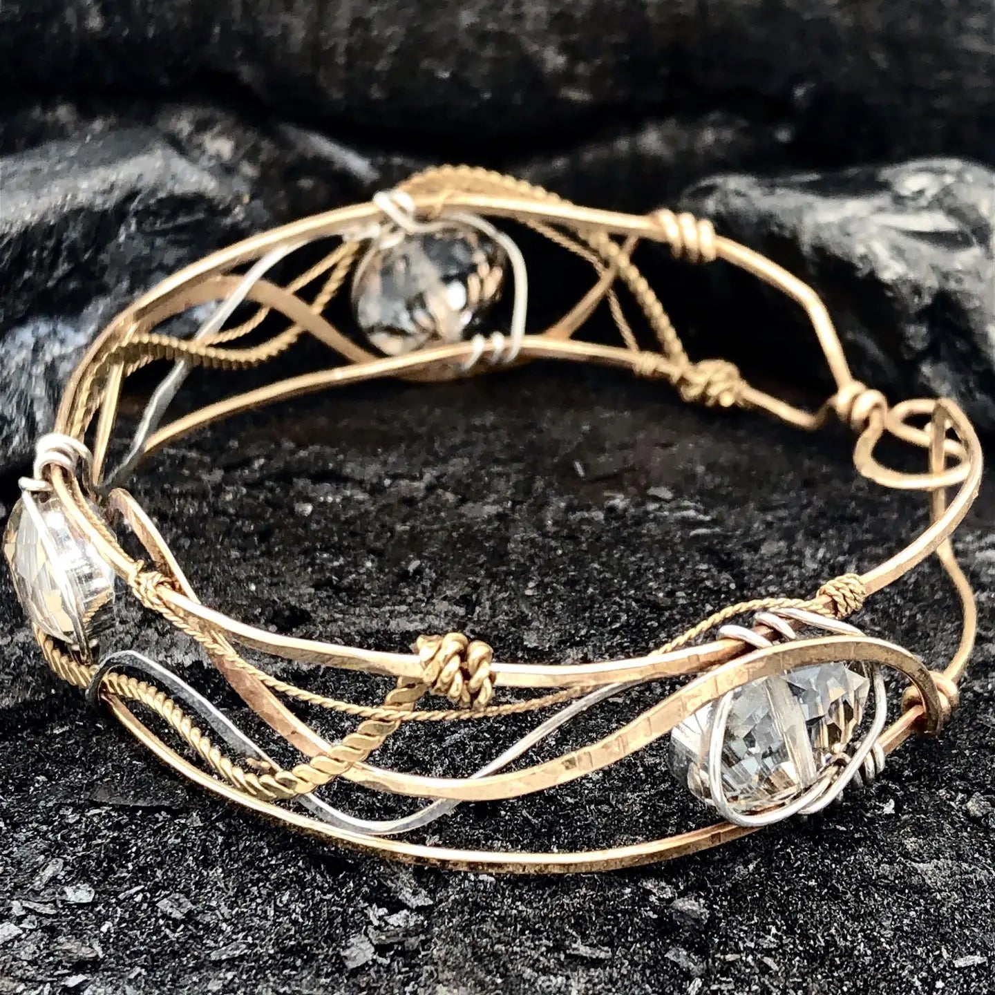 champagne colored faceted crystals held in braided layers of sterling silver, bronze and twisted brass hammered wires all inside a bronze cuff handmade bracelet
