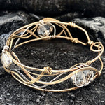 champagne colored faceted crystals held in braided layers of sterling silver, bronze and twisted brass hammered wires all inside a bronze cuff handmade bracelet
