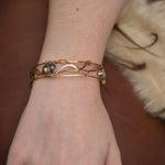 champagne colored faceted crystals held in braided layers of sterling silver, bronze and twisted brass hammered wires all inside a bronze cuff handmade bracelet