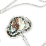 Necklace with a heart-shaped sterling silver hammered pendant featuring a gaspeite, turquoise, and pyrite gemstones