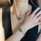 a turquoise smooth coin gemstone set in a hammered brass cuff bracelet, featuring a hand-formed clasp.