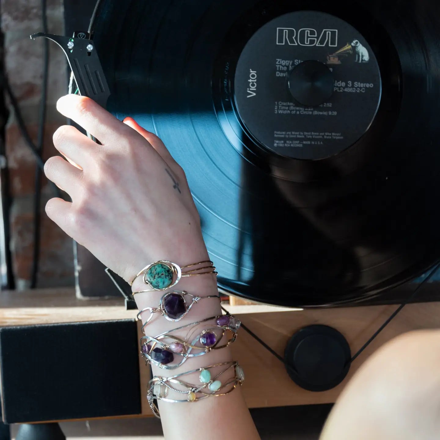 a turquoise smooth coin gemstone set in a hammered brass cuff bracelet, featuring a hand-formed clasp.