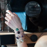 a turquoise smooth coin gemstone set in a hammered brass cuff bracelet, featuring a hand-formed clasp.